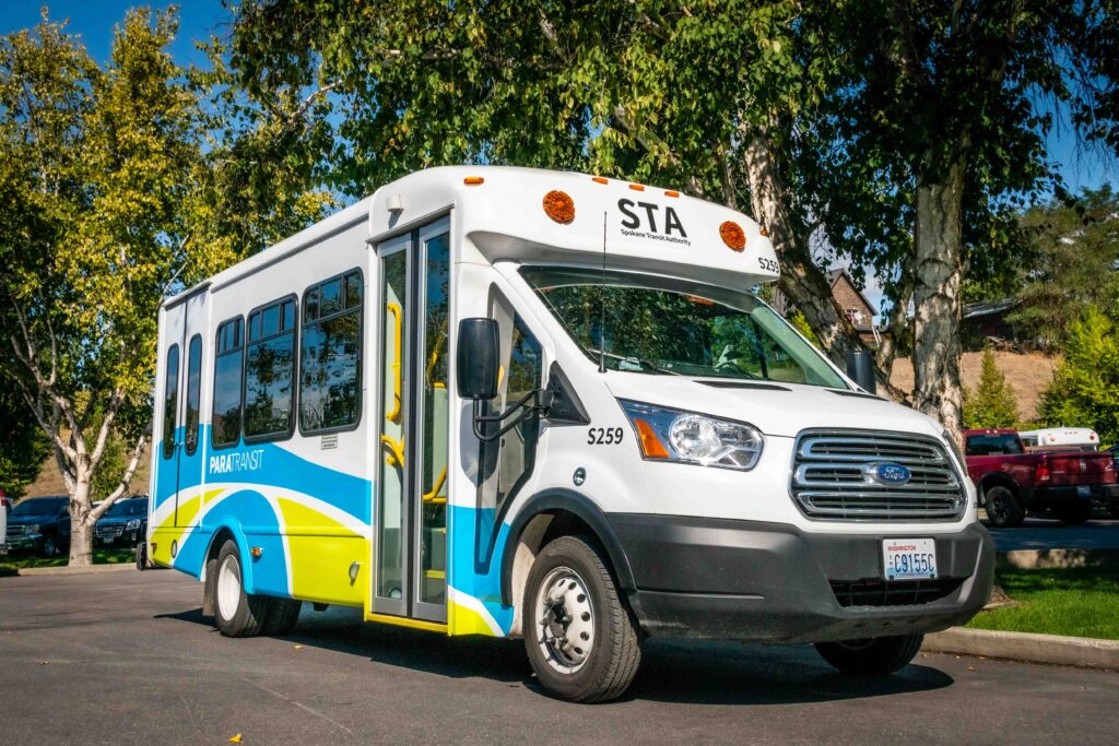 A white bus parked on the side of a road.