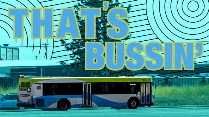 A city bus travels on a sunny day, with large blue and yellow text overlay that says "THAT'S BUSSIN'." The background features a teal and black lined pattern, along with industrial buildings and a tree.