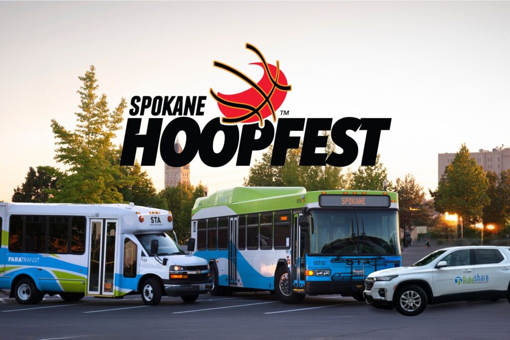 An image promoting Spokane Hoopfest, featuring a logo with a basketball hoop and backboard. In the foreground, there are a Spokane Transit Authority bus, a smaller paratransit vehicle, and a green and white VanPool car parked in an open area with trees and buildings in the background.