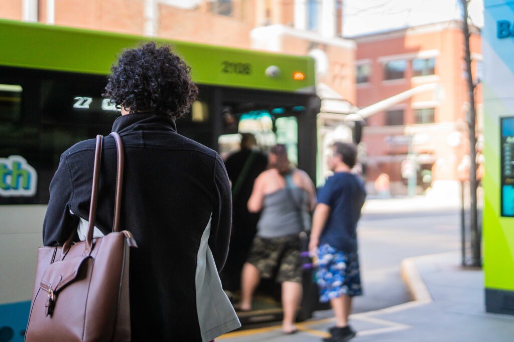 Person with a bag waits as people board an STA bus in downtown Spokane.
