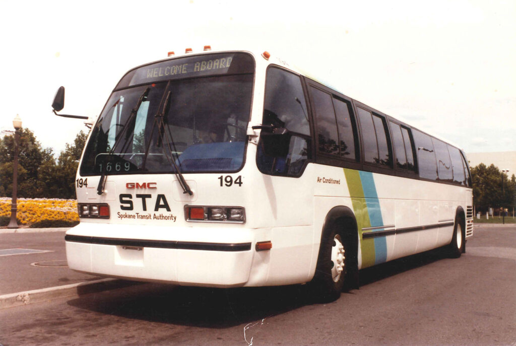 White GMC STA bus parked on a road, with "Welcome Aboard" displayed on the front.