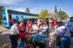 Attendees collect promo items from a table at the event.