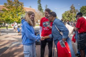 City of Spokane Council President and STA Board Member Besty Wilkerson shakes hands with an EWU student with STA CEO Karl Otterstrom looking on.