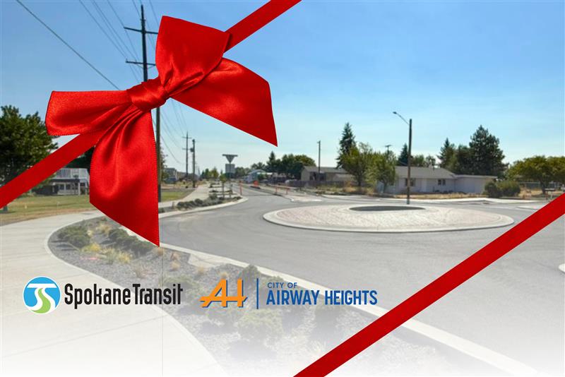 Roundabout with large red ribbon; Spokane Transit and Airway Heights logos in front.