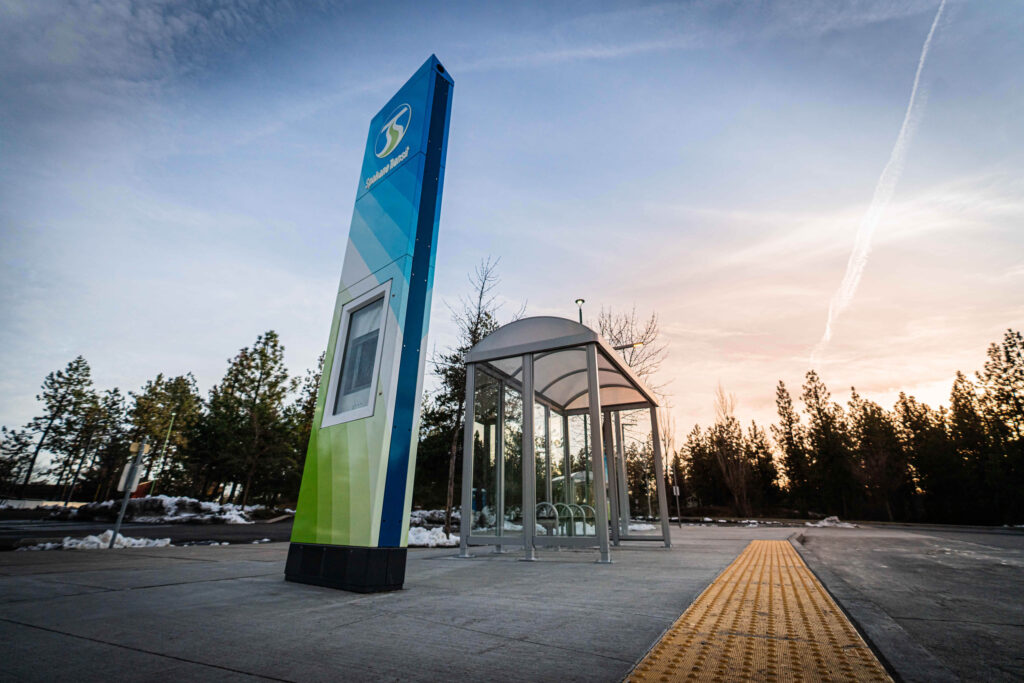 Bus stop with shelter and sign.