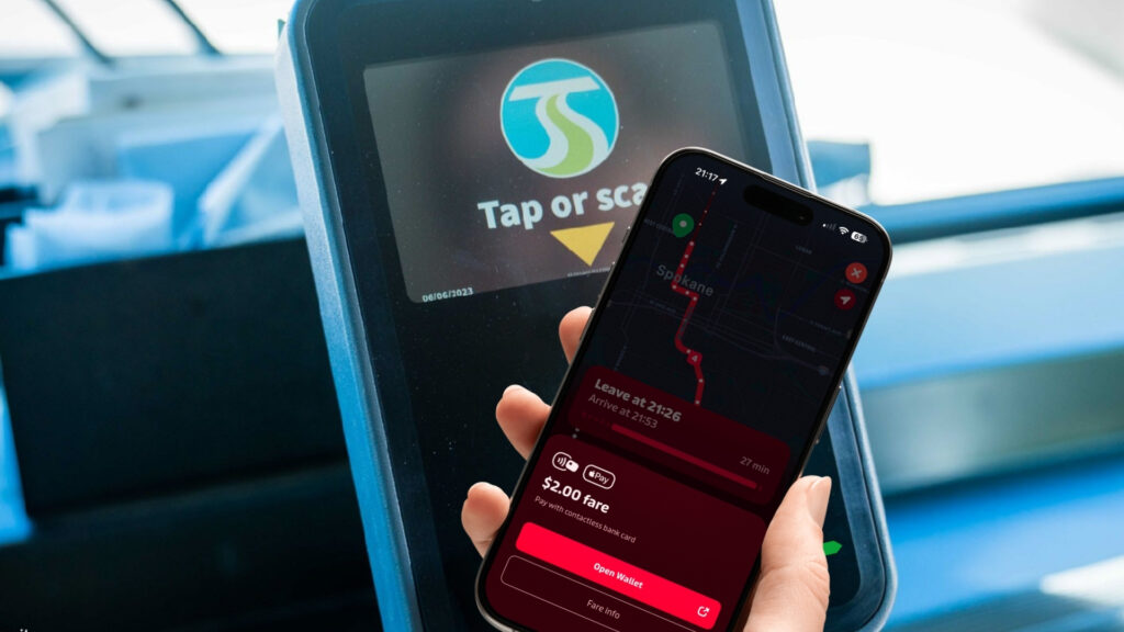 Phone displaying contactless fare payment via Apple Pay at an STA fare box.