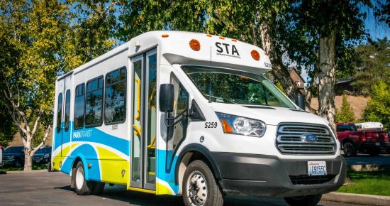 A white bus parked on the side of a road.