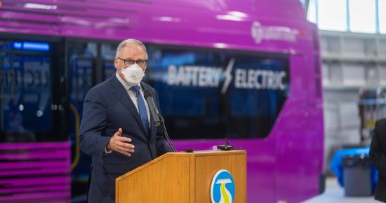 Governor Jay Inslee speaking to the press in front of a City Line bus rapid transit bus